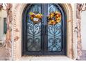 Close-up of the arched double front doors decorated with seasonal fall wreaths at 18425 W Santa Irene Dr, Goodyear, AZ 85338