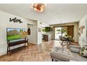 Open-concept living room featuring stylish decor, wood floors, and seamless flow to the dining area at 19025 N 96Th Ave, Peoria, AZ 85382