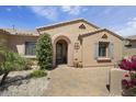 Close up on a home's arched entrance with shade shutters and verdant foliage at 19714 N Concord Dr, Surprise, AZ 85374