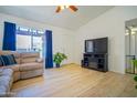 Bright living room with wood-look floors, large window, and cozy seating, creating a welcoming atmosphere at 2009 W Calle Del Norte Dr, Chandler, AZ 85224