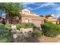 Inviting home with lush landscaping, complemented by a terracotta roof and a two-car garage at 22063 N 77Th St, Scottsdale, AZ 85255