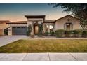 Charming home with manicured lawn, features a decorative iron door and neutral-toned stucco exterior at 2623 E Indigo Pl, Chandler, AZ 85286