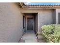 Close-up of the front entrance showing a secure door and desert landscaping, set against a textured exterior wall at 2730 E Desert Trumpet Rd, Phoenix, AZ 85048