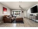 Cozy living room showcasing a comfortable leather sofa, modern ceiling fan, and stylish decor at 3759 E Charter Oak Rd, Phoenix, AZ 85032