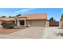 Inviting single-story home with a terracotta roof, two-car garage, desert landscaping, and gated driveway at 5860 W Saragosa St, Chandler, AZ 85226