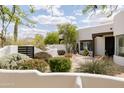 Beautiful Santa Fe home with lush desert landscaping, custom wood accents and a charming front courtyard at 8601 E De La O Rd, Scottsdale, AZ 85255