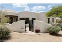Charming Santa Fe home with an inviting courtyard, beautiful desert landscaping and stylish front gate at 8601 E De La O Rd, Scottsdale, AZ 85255