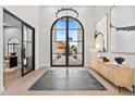 The home features a grand foyer with a large arched window, elegant light fixtures, and a modern console table at 9820 N 87Th Pl, Scottsdale, AZ 85258