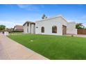 A bright, modern home featuring a well-manicured lawn and a gated garage, creating an inviting, yet private, curb appeal at 9820 N 87Th Pl, Scottsdale, AZ 85258