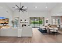 A modern living room and dining area with neutral tones, a fireplace, and sliding glass doors to the backyard at 9820 N 87Th Pl, Scottsdale, AZ 85258