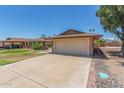 Single-story home with an attached garage, concrete driveway, and desert landscaping at 10236 N 105Th Dr, Sun City, AZ 85351