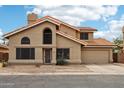 Two-story home with tan stucco, tile roof, and mature landscaping at 1344 N Brittany Ln, Gilbert, AZ 85233