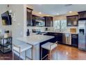 Modern kitchen features dark cabinetry, stainless steel appliances, quartz countertops, and hardwood floors at 15252 N 100Th St # 2157, Scottsdale, AZ 85260