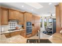 Well-lit kitchen boasting custom wood cabinets, granite counters, stainless appliances, and a breakfast nook with great views at 15502 W Agua Linda Ln, Surprise, AZ 85374