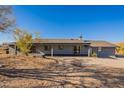 Rear exterior view of a gray single-story home with desert landscaping at 15612 S Tuthill Rd, Buckeye, AZ 85326
