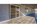 Covered patio with gray textured stucco and black tile at 15612 S Tuthill Rd, Buckeye, AZ 85326
