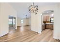 Bright open-concept living space featuring hardwood floors, modern light fixtures and an arched entry to kitchen at 17349 E Quail Ridge Dr, Fountain Hills, AZ 85268
