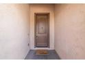 Inviting entryway showcasing a solid wood front door with a charming 'welcome' doormat at 18149 W Turney Ave, Goodyear, AZ 85395