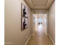 Hallway features decorative art, neutral paint, and tile flooring. Bright, spacious, and inviting at 18149 W Turney Ave, Goodyear, AZ 85395