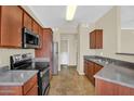 Well-lit kitchen with stainless steel appliances, wood cabinetry, and an adjacent laundry area at 1941 S Pierpont Dr # 1014, Mesa, AZ 85206