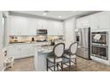 Bright kitchen with white cabinetry, stainless steel appliances, and granite countertops with seating at 1941 W Yellowstone Way, Chandler, AZ 85248