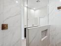 Modern bathroom features glass shower with white marble-style tiling and dark vanity at 19550 N Grayhawk Dr # 1144, Scottsdale, AZ 85255