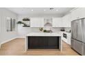 Modern kitchen boasts a marble island, white cabinets, stainless steel appliances and stylish decor at 19550 N Grayhawk Dr # 1144, Scottsdale, AZ 85255