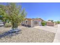 The low-maintenance front yard features desert landscaping and a cute decorative bench at 2041 E Des Moines St, Mesa, AZ 85213