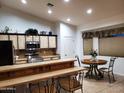 Bright kitchen featuring tiled countertops, stainless steel appliances, breakfast bar, and a cozy dining area with a round table at 2101 S Meridian Rd # 437, Apache Junction, AZ 85120