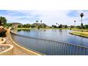 Enjoy the water view with an iron fence overlooking a lake and green hills at 21609 N 61St Ave, Glendale, AZ 85308