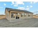 The rear exterior view reveals a cozy covered patio and multiple windows for ample natural light at 22351 S Manzanilla Rd, Buckeye, AZ 85326