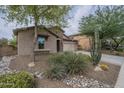 Attractive front exterior with desert landscaping, including lush plantings, a stone accent wall, and a view of the garage at 3721 W Aracely Dr, New River, AZ 85087