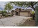 Charming single-story home with a stone facade, low-maintenance front yard, and a wide driveway leading to a two-car garage at 3721 W Aracely Dr, New River, AZ 85087