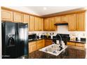 Well-lit kitchen features granite countertops, wood cabinetry, and modern stainless-steel appliances with ample counterspace at 3756 E Alamo St, San Tan Valley, AZ 85140