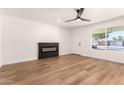 Bright living room featuring wood floors, a modern fireplace, ceiling fan and ample natural light at 4147 W Reade Ave, Phoenix, AZ 85019