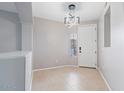 This modern entryway features tile flooring, a statement light fixture, and a neutral color palette at 421 W Mountain Sage Dr, Phoenix, AZ 85045