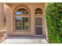 Inviting front entrance showcasing a charming door with security screen, decorative windows, and desert landscaping at 4426 E Coyote Wash Dr, Cave Creek, AZ 85331