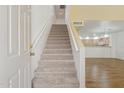 Stairway leading upstairs, with light carpet and railing, with partial view of kitchen at 4734 W Golden Ln, Glendale, AZ 85302