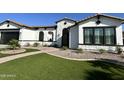 Beautiful home featuring a well-manicured lawn, a stone facade, a tile roof, and a welcoming walkway at 5088 S Ponderosa Dr, Gilbert, AZ 85298