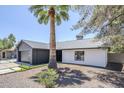 Well-maintained single-story home with a gray garage and xeriscaping against a clear blue sky at 5239 E Waltann Ln, Scottsdale, AZ 85254