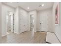 Open entryway featuring light wood-look floors, neutral walls, and ample closet space at 5954 E Cat Balue Dr, Phoenix, AZ 85054