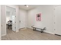 Bright entryway with decorative painting, light wood-look floors, and a comfortable bench at 5954 E Cat Balue Dr, Phoenix, AZ 85054