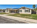 Street view of single-story home featuring solar panels and inviting covered entrance at 624 N Ashbrook Cir, Mesa, AZ 85213