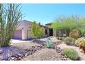 Charming home featuring desert landscaping with native plants, rocks, and gravel, offering a low-maintenance appeal at 6937 E Purple Shade Cir, Scottsdale, AZ 85266