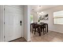 The front door leads to a dining area with a dark wood table and tile flooring at 7324 S 254Th Dr, Buckeye, AZ 85326