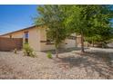 The home has a low-maintenance desert-style landscape with mature trees providing ample shade at 7324 S 254Th Dr, Buckeye, AZ 85326
