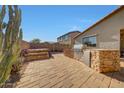 The backyard offers an outdoor kitchen with a barbecue and stone fire pit with room to entertain at 8687 W Bajada Rd, Peoria, AZ 85383
