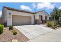 Exterior showcasing the well-manicured front yard, long driveway, and two-car garage at 9921 E Acceleration Dr, Mesa, AZ 85212