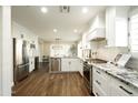 Beautiful kitchen featuring stainless steel appliances, white cabinets, granite countertops, and wood flooring at 10284 E Mallow Cir, Scottsdale, AZ 85255