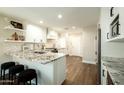 Kitchen offers white cabinets, granite countertops, stainless steel appliances, and breakfast bar seating at 10284 E Mallow Cir, Scottsdale, AZ 85255